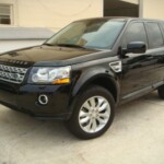 Before and after photographs of a damaged, black, Range Rover that was repaired by Elite Paint & Body Shop in West Palm Beach, FL.